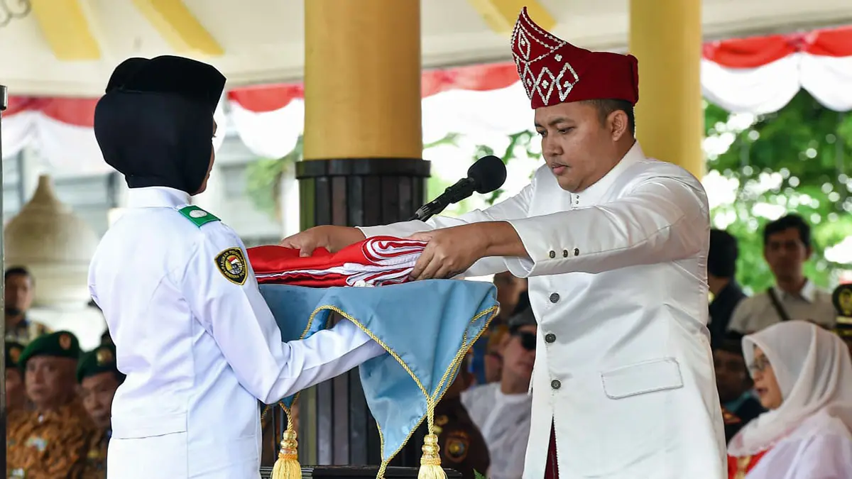 SAKRAL: Bupati Pasuruan Mas Rusdi saat menyerahkan sang saka merah putih untuk dikibarkan di upacara HUT ke-81 RI. (Mokhamad Zubaidillah/ Radar Bromo)