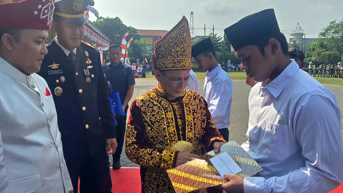 Wabup Shobih Asrori saat menyerahkan berkas remisi ke salah satu perwakilan WBP disaksikan Bupati Pasuruan Rusdi Sutejo. (M Busthomi/ Radar Bromo)