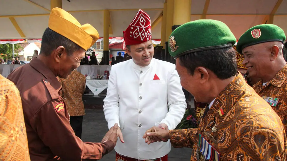 ADAT KALSEL: Bupati Rusdi yang mengenakan baju adat Kalimantan menyalami para veteran setelah upacara. (Foto: M Zubaidillah/Jawa Pos Radar Bromo)
