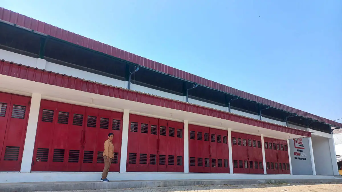 TERBANGUN: Bendahara Desa Tongas Wetan, Jijin Giharsusi saat di depan gedung KDKMP milik Desa Tongas Wetan. (Foto: Inneke Agustin/Jawa Pos Radar Bromo)