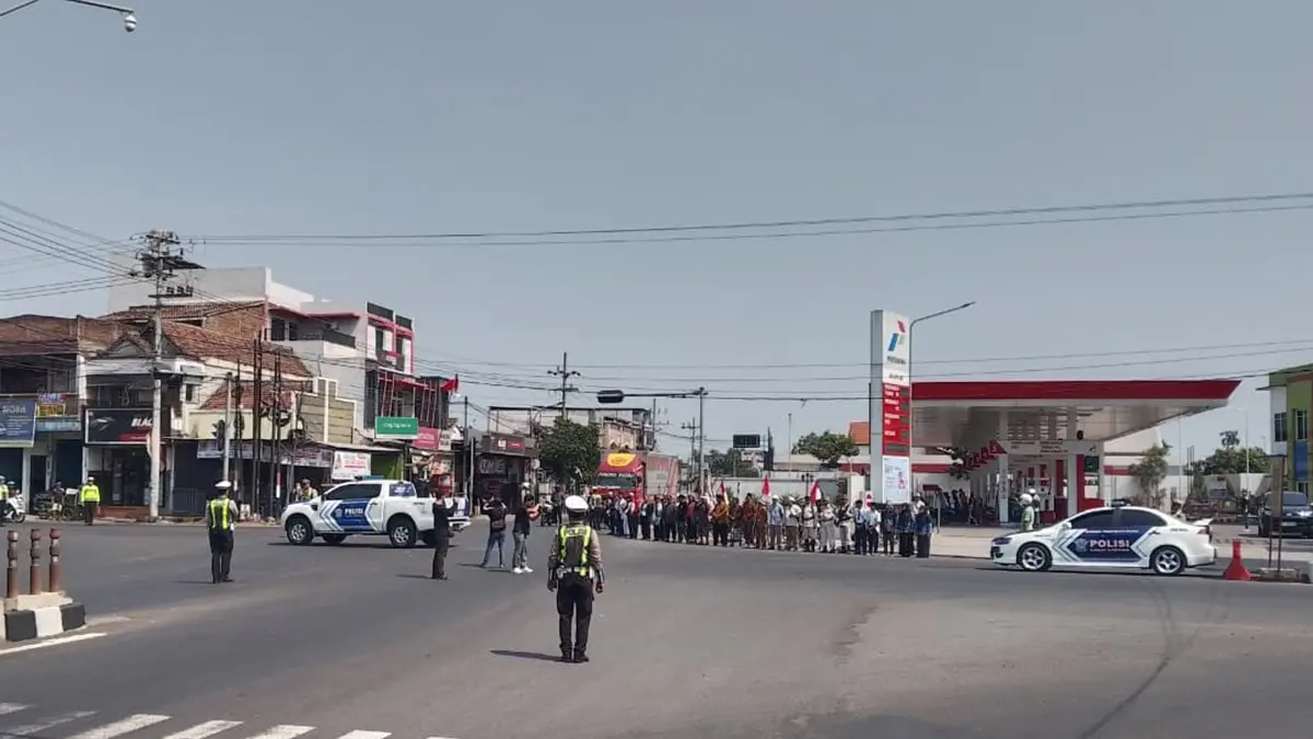 MERDEKA: Sejumlah pengguna jalan berhenti sejenak di Simpang Empat Kebonagung, Kota Pasuruan. Mereka mengikuti peringatan detik-detik Proklamasi HUT Kemerdekaan ke-81 Republik Indonesia, Senin (17/8), tepat pukul 10.00. (POLRES PASURUAN KOTA FOR JAWA POS RADAR BROMO)