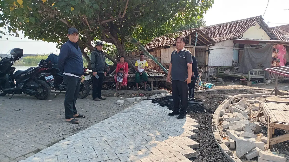 CEK PEMBANGUNAN: Sekretaris Desa Kalibuntu Misliyanto (kiri) bersama Kaur Keuangan Alan Yudistira, mengecek pembangunan jalan paving Di Dusun Landangan RT 1/RW 1. (Didik Purwanto/Radar Bromo)