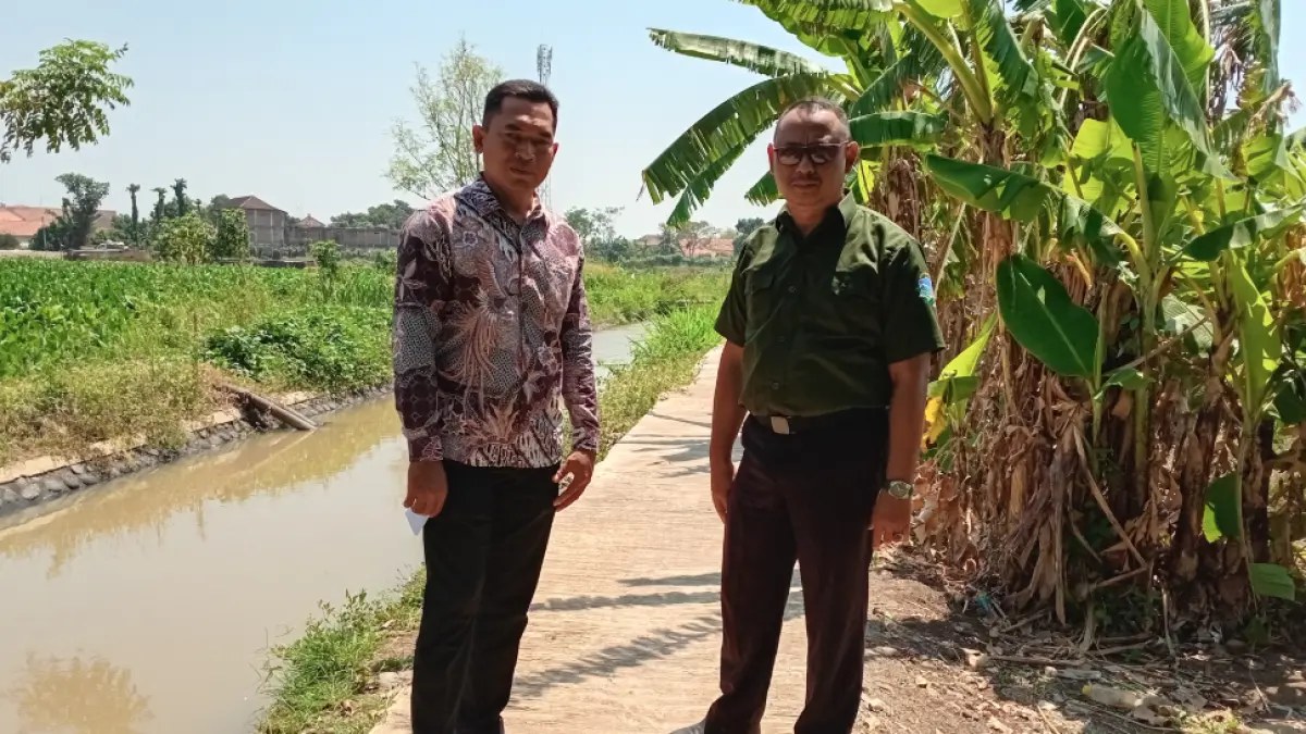 JALAN USAHA TANI: Sekretaris Desa Rustam Efendi (baju hijau) bersama Kasi Pembangunan Mahmudi menunjukkan jalan rabat beton di Dusun Sumber RT 2/RW 1, sebelum dibangun kondisinya tidak layak untuk dilewati. (DIDIK PURWANTO/JAWA POS RADAR BROMO)