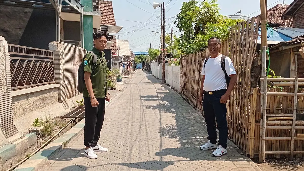 MAKIN NYAMAN: Kasi Pembangunan Desa Asembagus Budi Hartono (kaus putih) bersama Operator Desa Opon Rachmad melintas di jalan paving Dusun Asemkandang RT 1/RW 2. (DIDIK PURWANTO/JAWA POS RADAR BROMO)