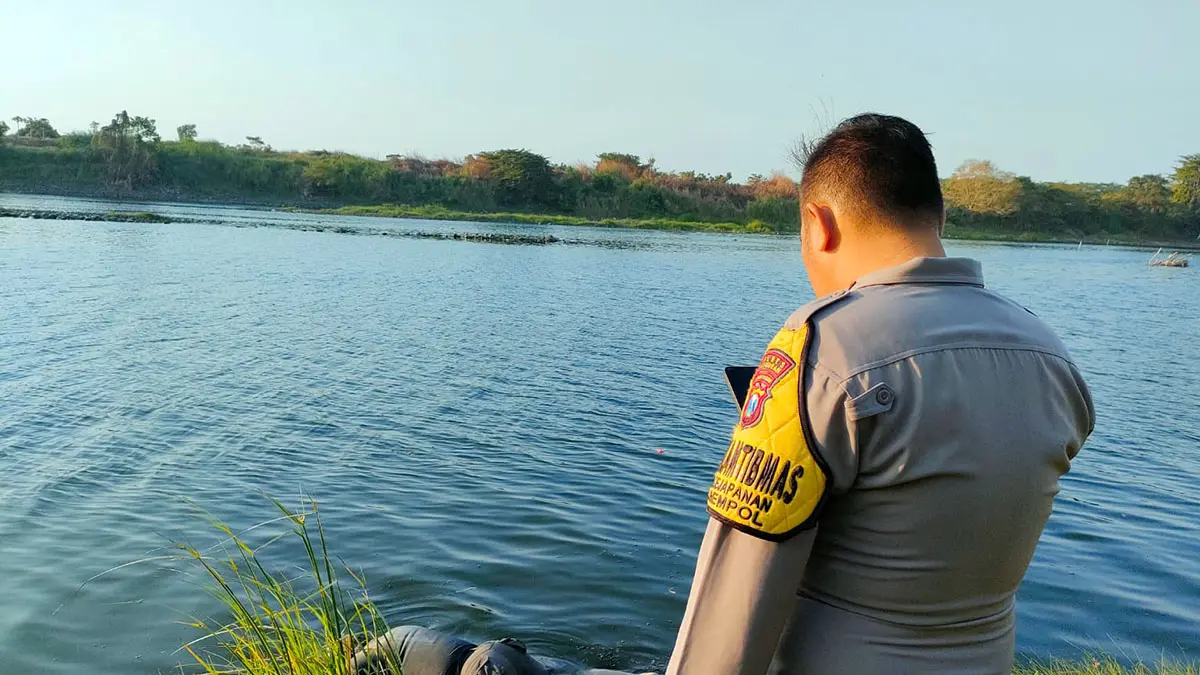 MASIH MISTERI: Petugas saat hendak mengevakuasi jenazah Mr X yang ditemukan mengapung di Kali Porong, Sabtu sore (22/8).