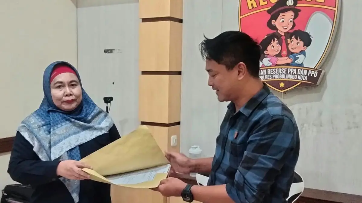 PENYERAHAN: Kuasa hukum korban, Siti Zuroidah menyerahkan surat permohonan restitusi kepada Kanit PPA Satreskrim Polres Probolinggo Kota Aiptu Roby Adi di Polres Probolinggo Kota, Selasa (18/8). (ISTIMEWA)