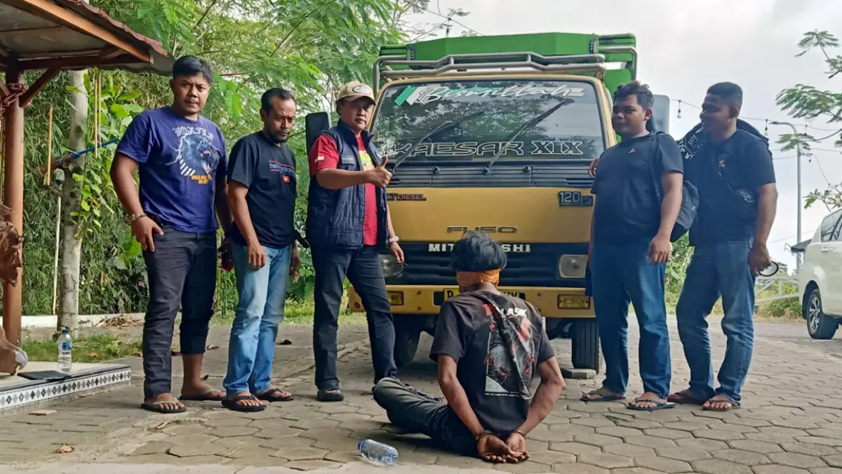 Samsul Arifin, 45 (membelakangi kamera) saat dibekuk petugas. 