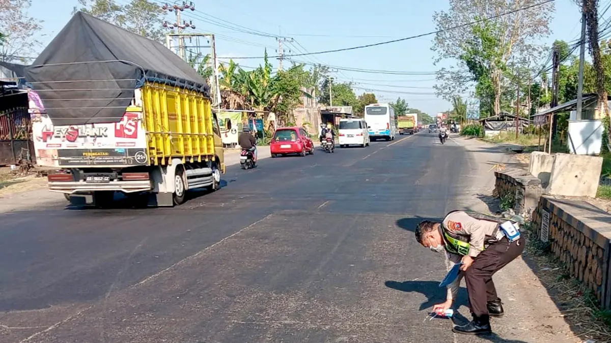 LOKASI KEJADIAN: Petugas Satlantas Polres Probolinggo melakukan olah TKP kecelakaan di jalan pantura Desa Randupitu, Kecamatan Gending. (Foto : Satlantas Polres Probolinggo for Jawa Pos Radar Bromo)