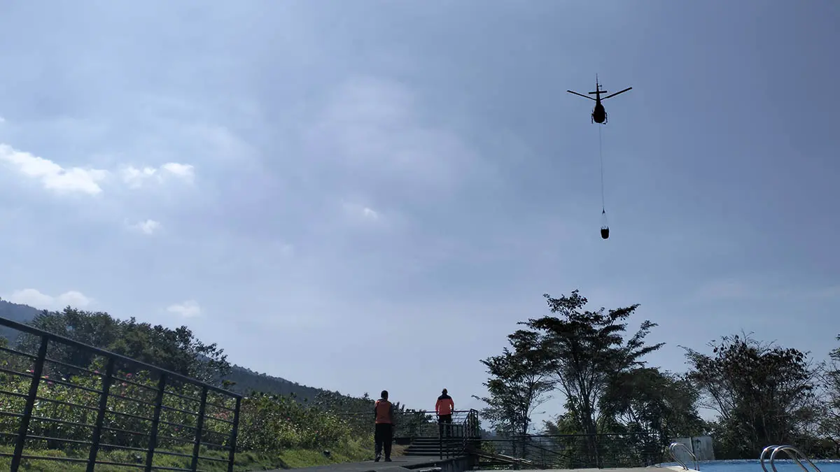 SUPLAI AIR: Helikopter jenis Airbus milik BPBD Provinsi Jatim saat mengambil air di kolam kawasan Kaliandra, Desa Dayurejo, Kecamatan Prigen, Senin (24/8). (Rizal Syatori/Radar Bromo)