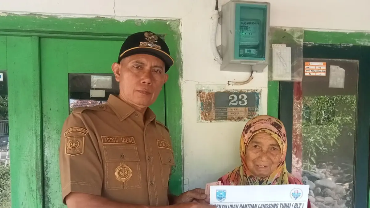 BANTU WARGA: Kepala Desa Widoro Abdul Jalal menyerahkan BLT-DD kepada salah seorang warganya. (PEMERINTAH DESA WIDORO FOR JAWA POS RADAR BROMO)