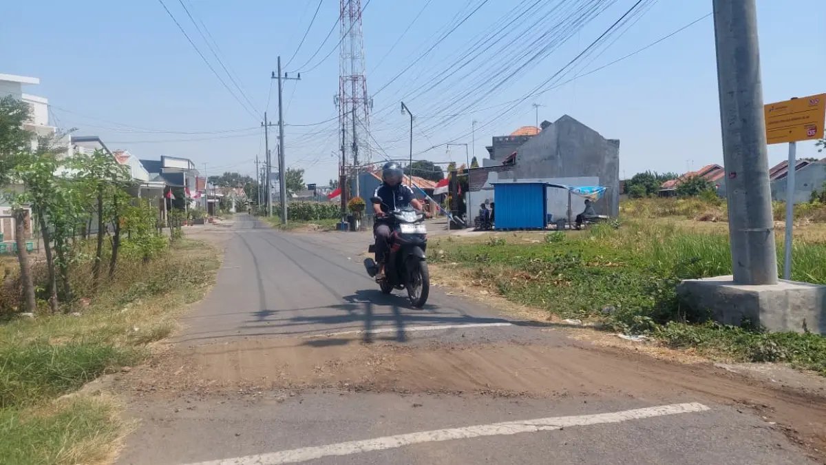 BERGELOMBANG: Pelat deker di Jalan Gunung Jati, Kelurahan Kebonsari Wetan, Kecamatan Kanigaran, ambles. (ARIF MASHUDI/JAWA POS RADAR BROMO)