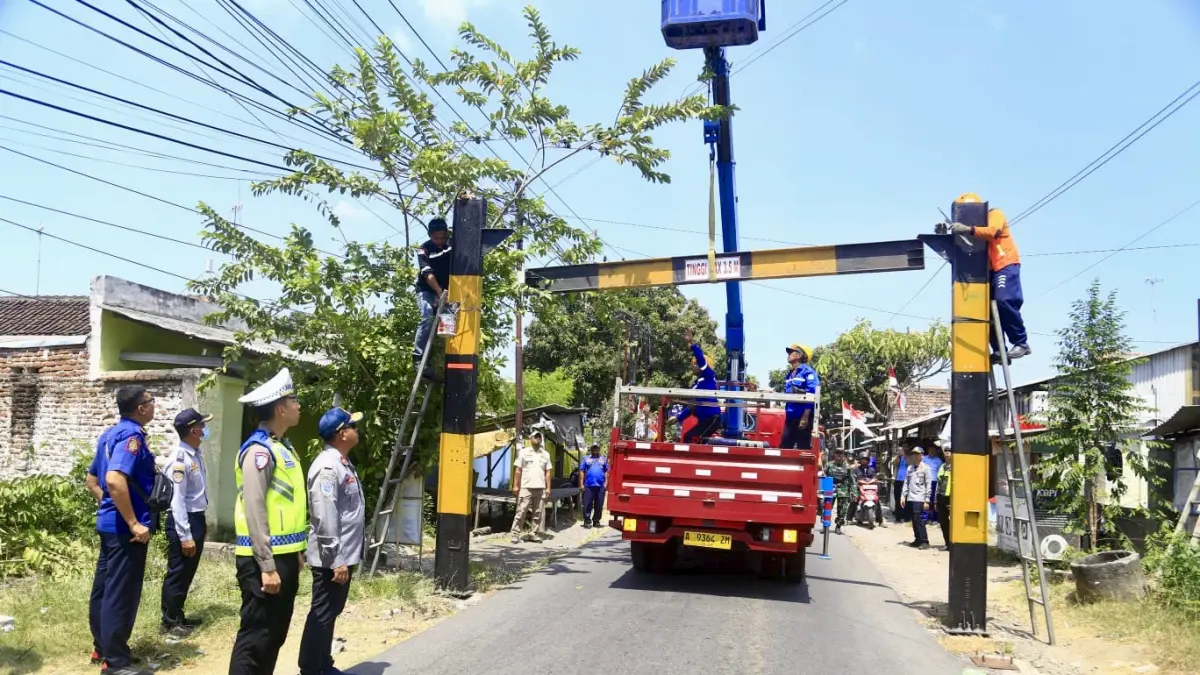 DIPASANG: Dishub Kabupaten Probolinggo memasang portal di Simpang Tiga Sinto Desa Tamansari, Kecamatan Dringu. (DISHUB FOR JAWA POS RADAR BROMO)