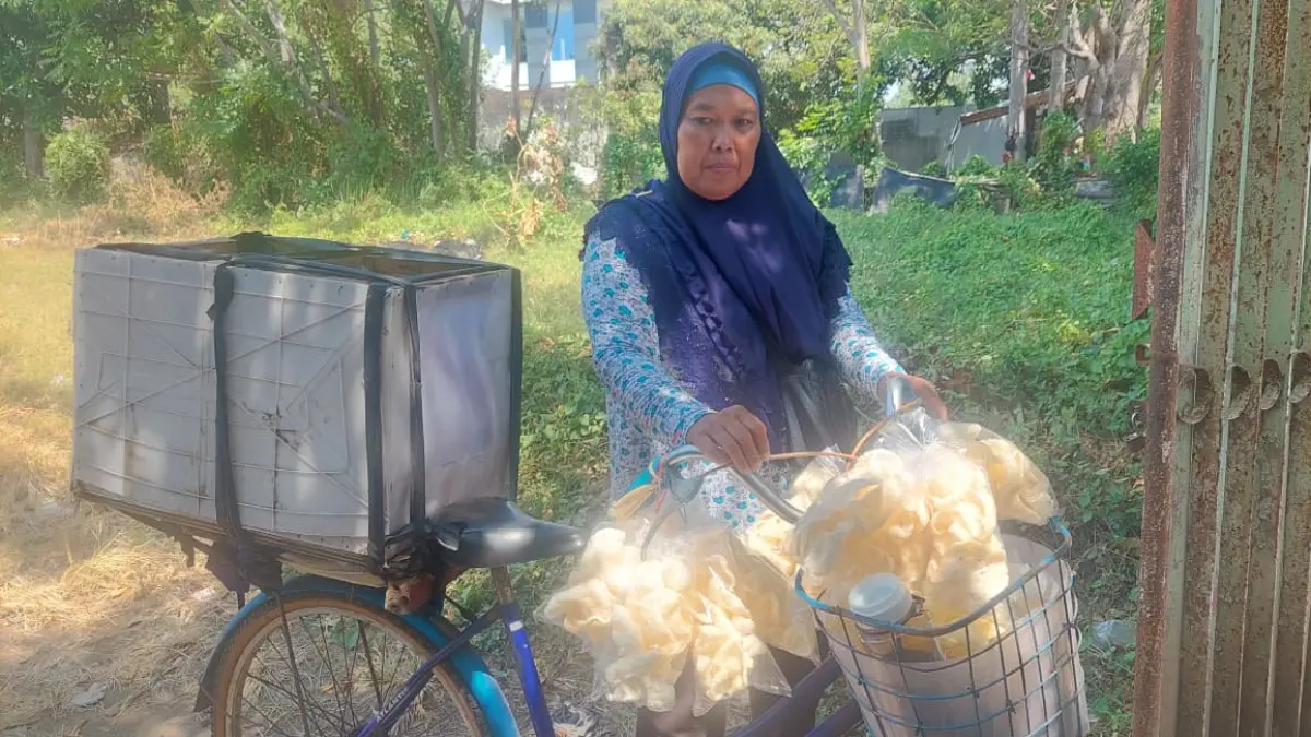 MENGAIS REZEKI: Indri Diah menjajakan kerupuk untuk menyambung hidup. Warga yang tinggal di Rusunawa Bestari, ini masuk desil 6-10. (ARIF MASHUDI/JAWA POS RADAR BROMO)
