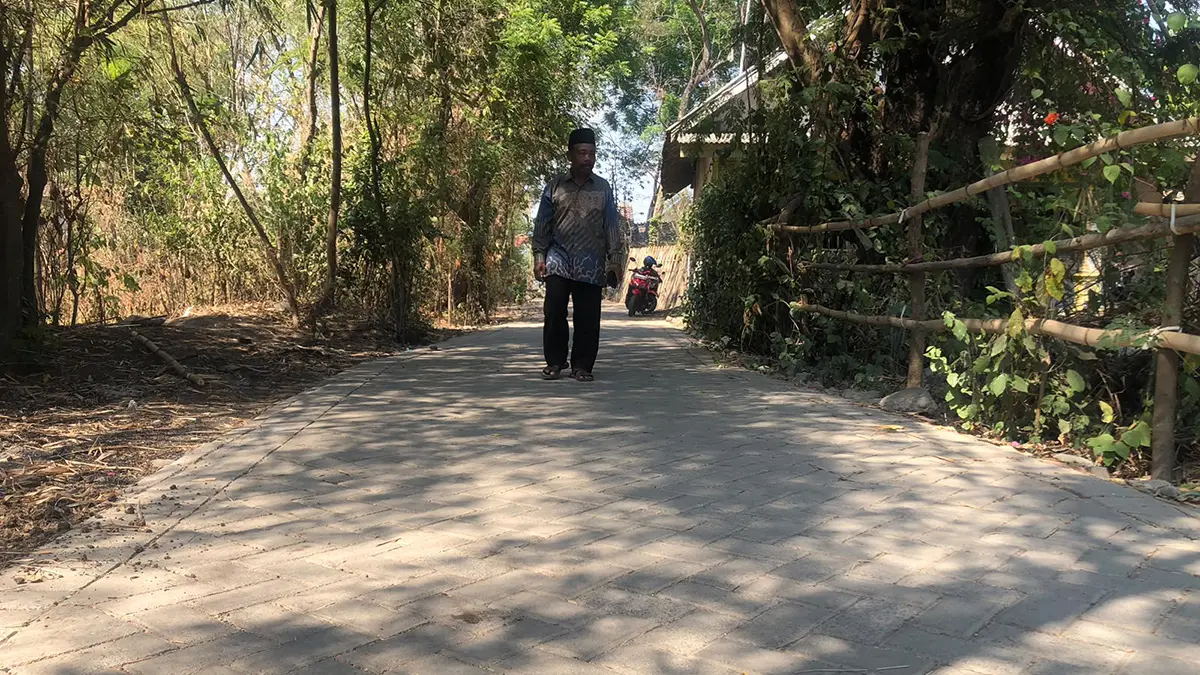 NYAMAN: Sekretaris Desa Sumendi Juardi di lokasi pavingisasi jalan Dusun Polai, Desa Sumendi, Kecamatan Tongas.