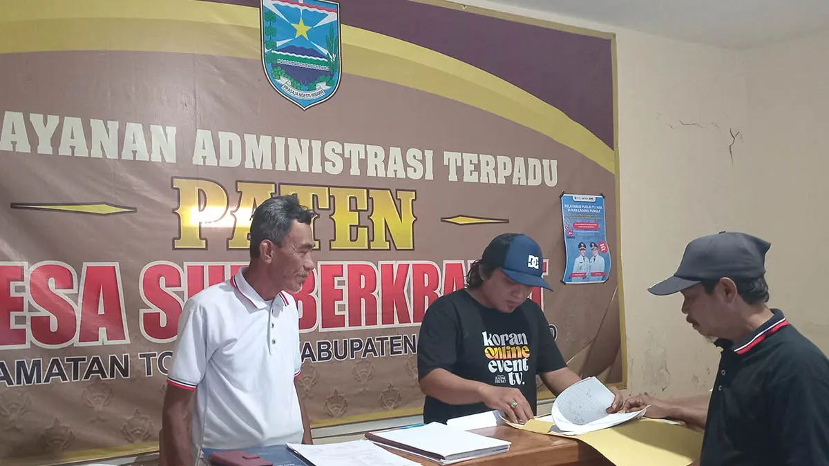 PELAYANAN: Bendahara Desa Sumber Kramat Rahman (kaus hitam) bersama Sekretaris Desa Salam, memberikan pelayanan administrasi di ruang pelayanan.&nbsp;(Foto: Didik Purwanto/Jawa Pos Radar Bromo)