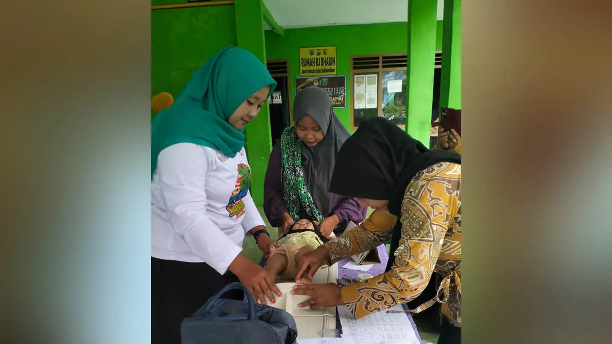 SEHAT&nbsp;: Koordinator Kader Posyandu Desa Sumber Kramat Luluk Anisa (kaos putih) &nbsp;membersamai pengukuran tinggi badan balita di kegiatan posyandu desa. (Foto: Didik Purwanto/Jawa Pos Radar Bromo)