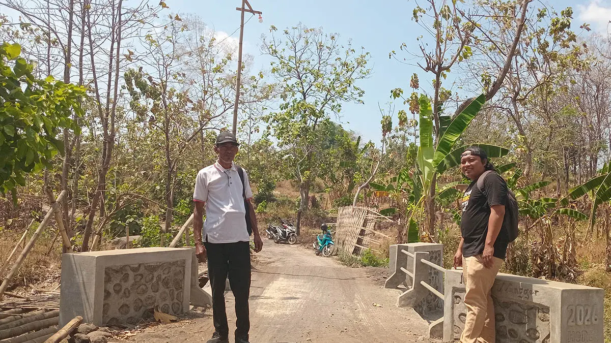 SWADAYA MASYARAKAT: Bendahara Desa Sumber Kramat Rahman (kaus hitam) bersama Salam Sekretaris Desa, menunjukan Jembatan Nangger hasil pembangunan swadaya gotong royong masyarakat.&nbsp;(Foto: Didik Purwanto/Jawa Pos Radar Bromo)
