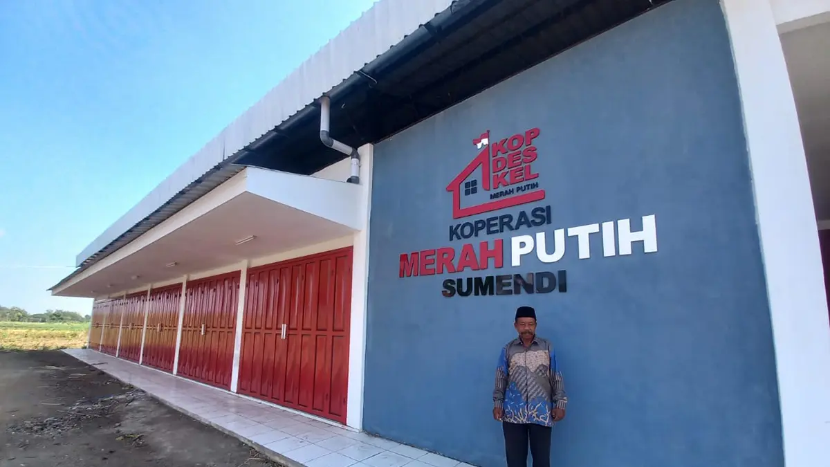 TERBANGUN: Sekretaris Desa Sumendi Juardi di depan Gedung KDMP Desa Sumendi, Kecamatan Tongas.