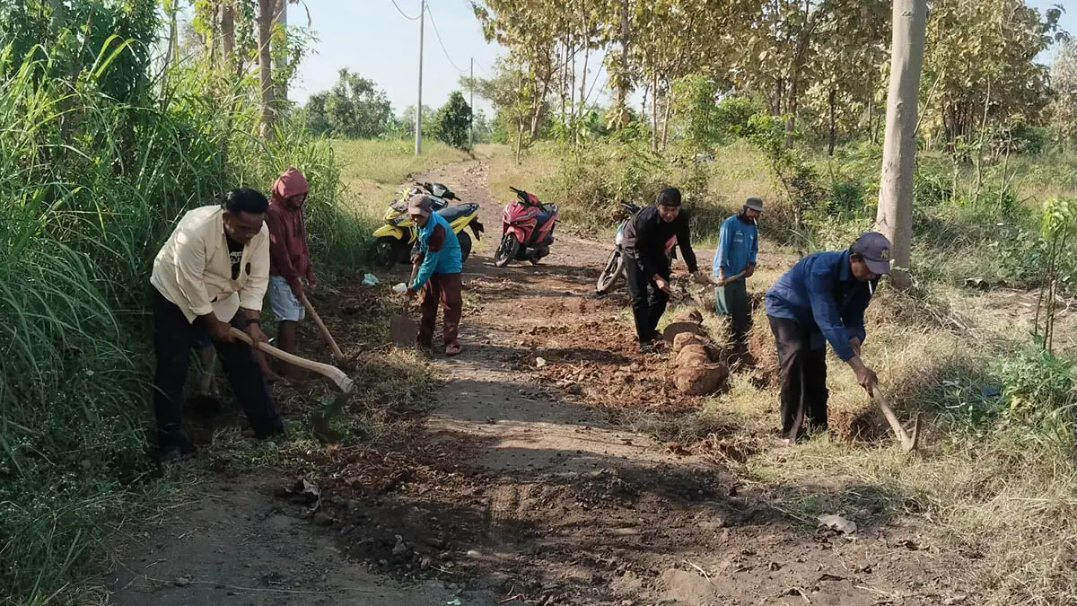 TURUN LANGSUNG: Kepala Desa Sumber Kramat &nbsp;H. Jumadi (depan baju putih) bergabung bersama warga melakukan pengurukan jalan di Dusun Mendek Wetan RT 6 dan 7/RW 3 dan 4. (Foto: Didik Purwanto/Jawa Pos Radar Bromo)