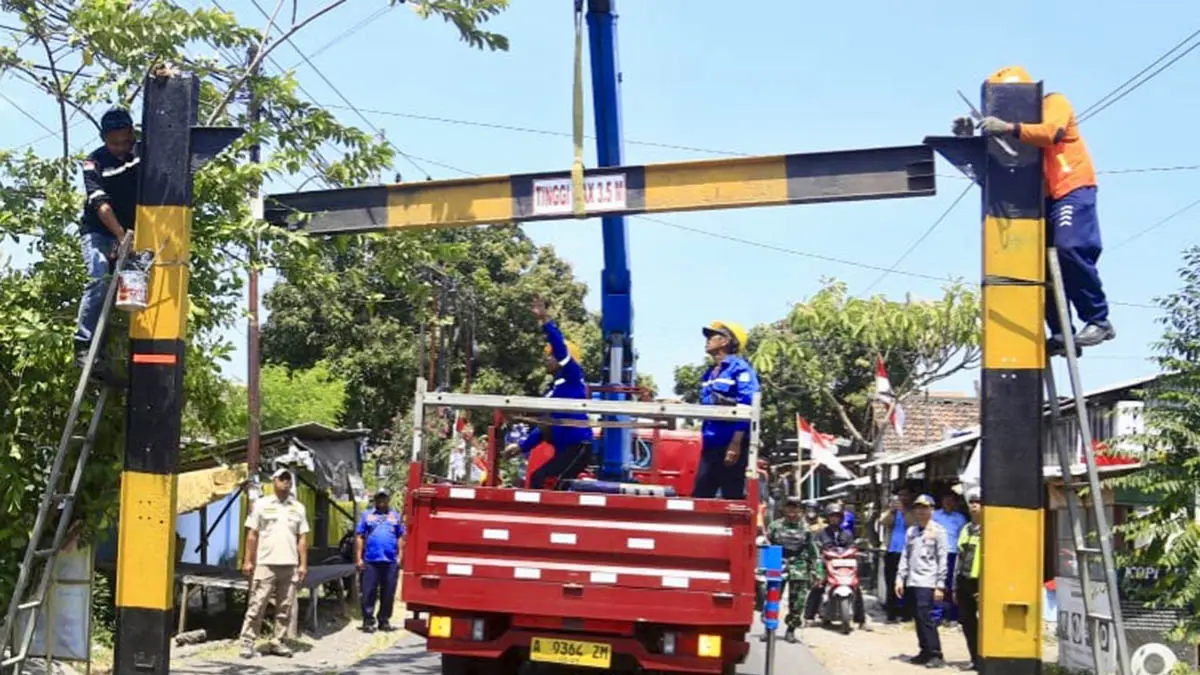 KOKOH: Petugas memasang portal di ruas jalan Desa Tamansari, Kecamatan Dringu. Ruas jalan lainnya bertahap dipasang. (Foto: dok Jawa Pos Radar Bromo)
