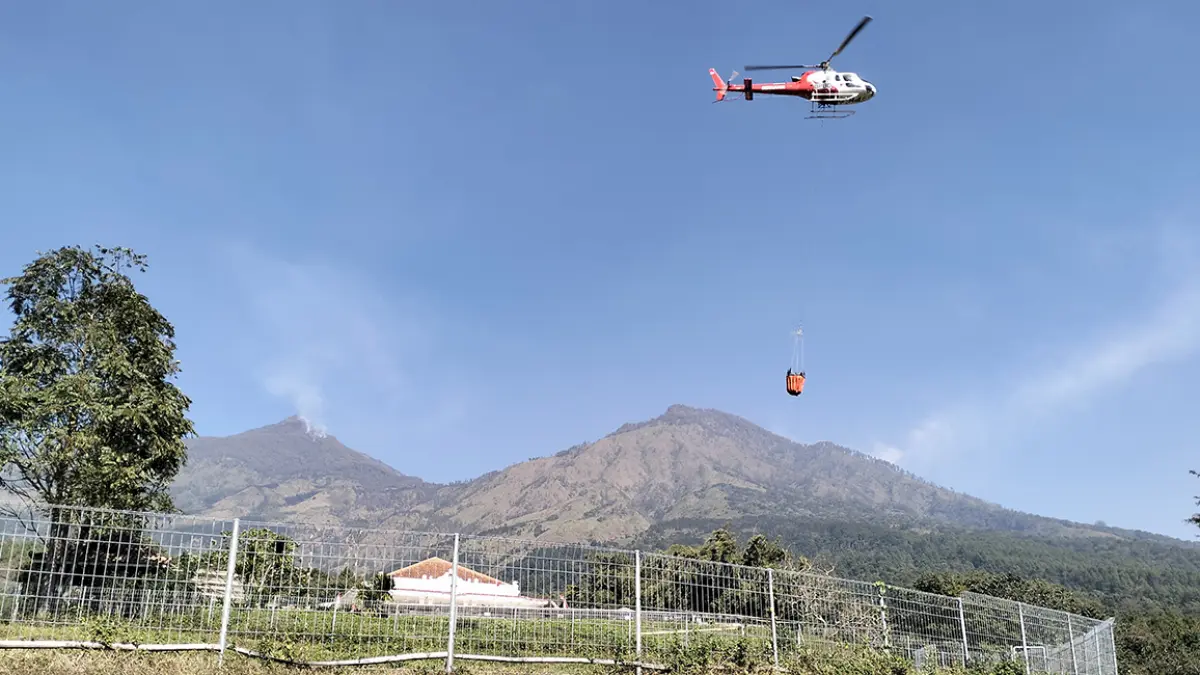 TERKENDALA CUACA: Helikopter water bombing saat membawa air dari kolam Kaliandra untuk padamkan api di blok Alas Lali Jiwo, lereng Gunung Arjuno, Kamis (27/8). (Rizal Syatori/ Radar Bromo)