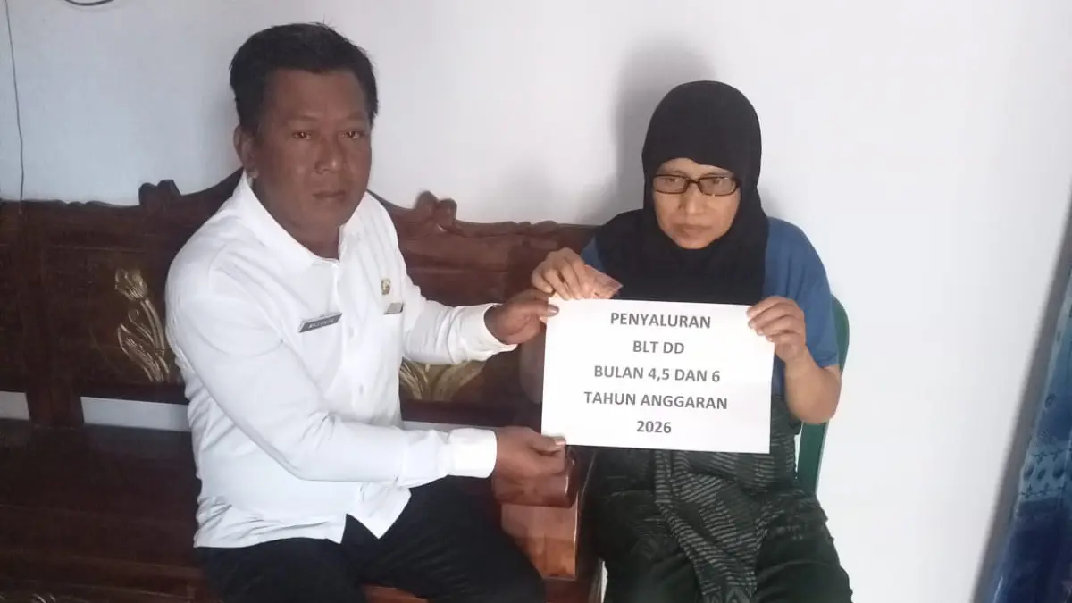 BANTU WARGA: Kepala Desa Rawan Mustofa menyalurkan BLT DD kepada salah satu KPM. (PEMERINTAH DESA RAWAN FOR JAWA POS RADAR BROMO)