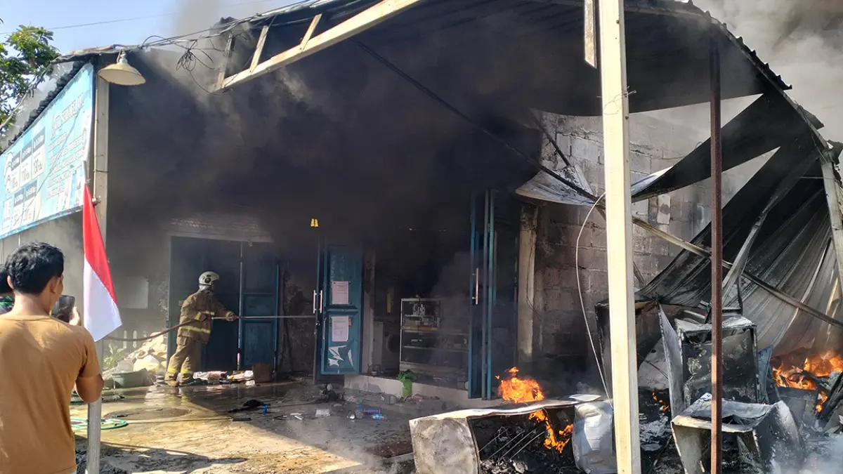 JINAKKAN API: Petugas pemadam kebakaran (damkar) menyemprotkan air untuk memadamkan sisa api yang menghanguskan rumah sekaligus toko servis elektronik milik Eko Junianto di Lingkungan Kuti II, Kelurahan Kutorejo, Kecamatan Pandaan. (Rizal Syatori/ Radar Bromo)	