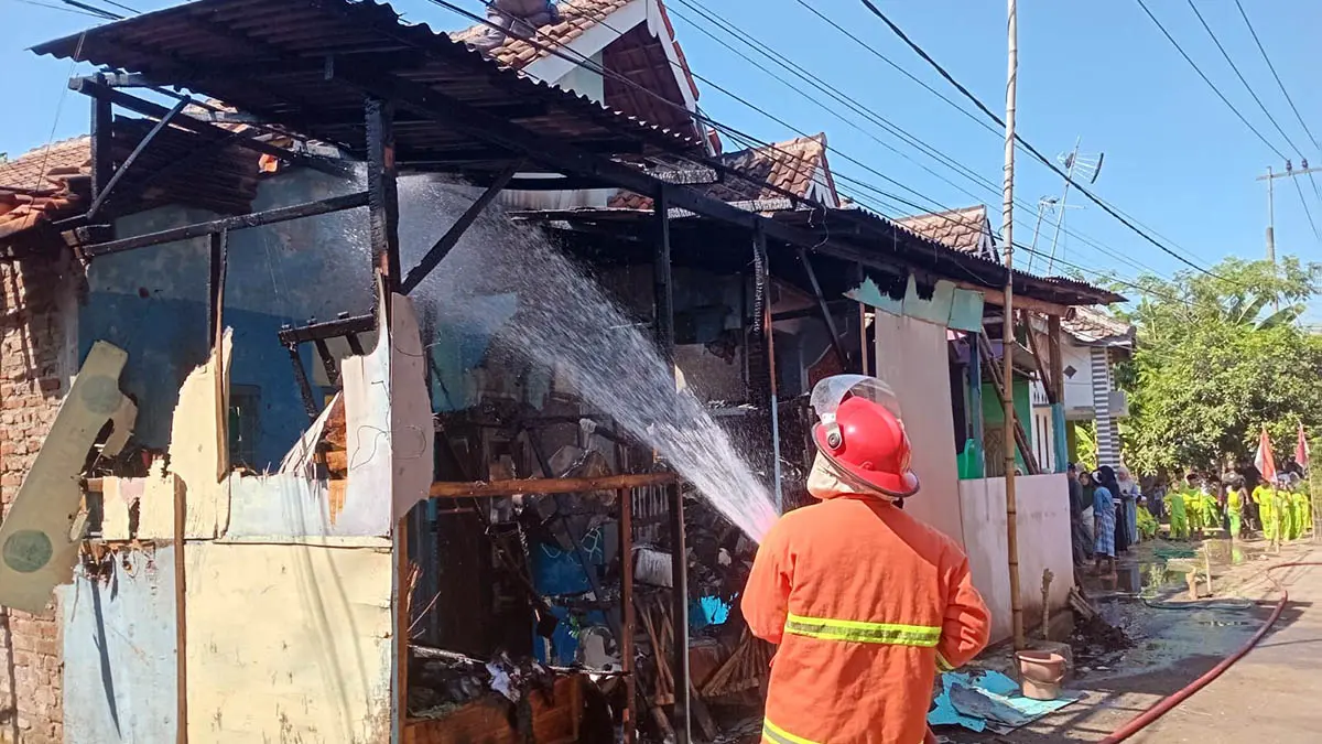 JINAKKAN API: Petugas pemadam kebakaran (Damkar) menyemprotkan air untuk menjinakkan api yang menghanguskan ruang dapur milik warga di RT 01 RW 03 Desa Karangpandan, Kecamatan Rejoso. (Humas Polres Pasuruan Kota for Radar Bromo)