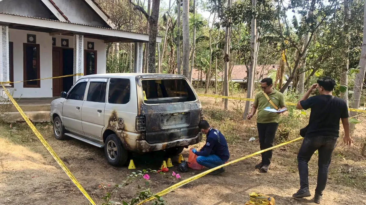 PASANG POLICE LINE: Petugas kepolisian saat melakukan olah TKP mobil kontraktor yang terbakar. Diduga mobil itu dibakar orang tak dikenal. 
