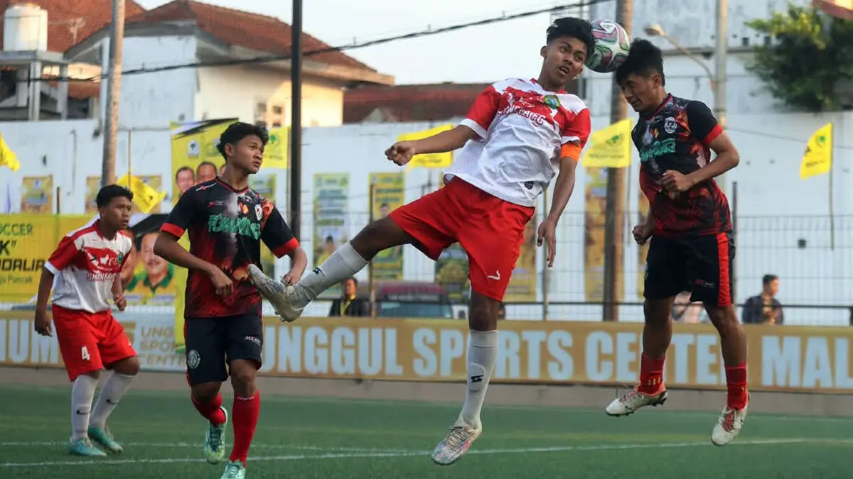 WAKILI MALANG: Penggawa Tim SMAN 1 Tumpang berebut bola atas dengan pemain MAN 1 Malang dalam laga semifinal pertama Bahlil Mini Soccer Asyik Menuju Puncak Zona Malang, Selasa sore (1/9). (Darmono/ Radar Malang) 