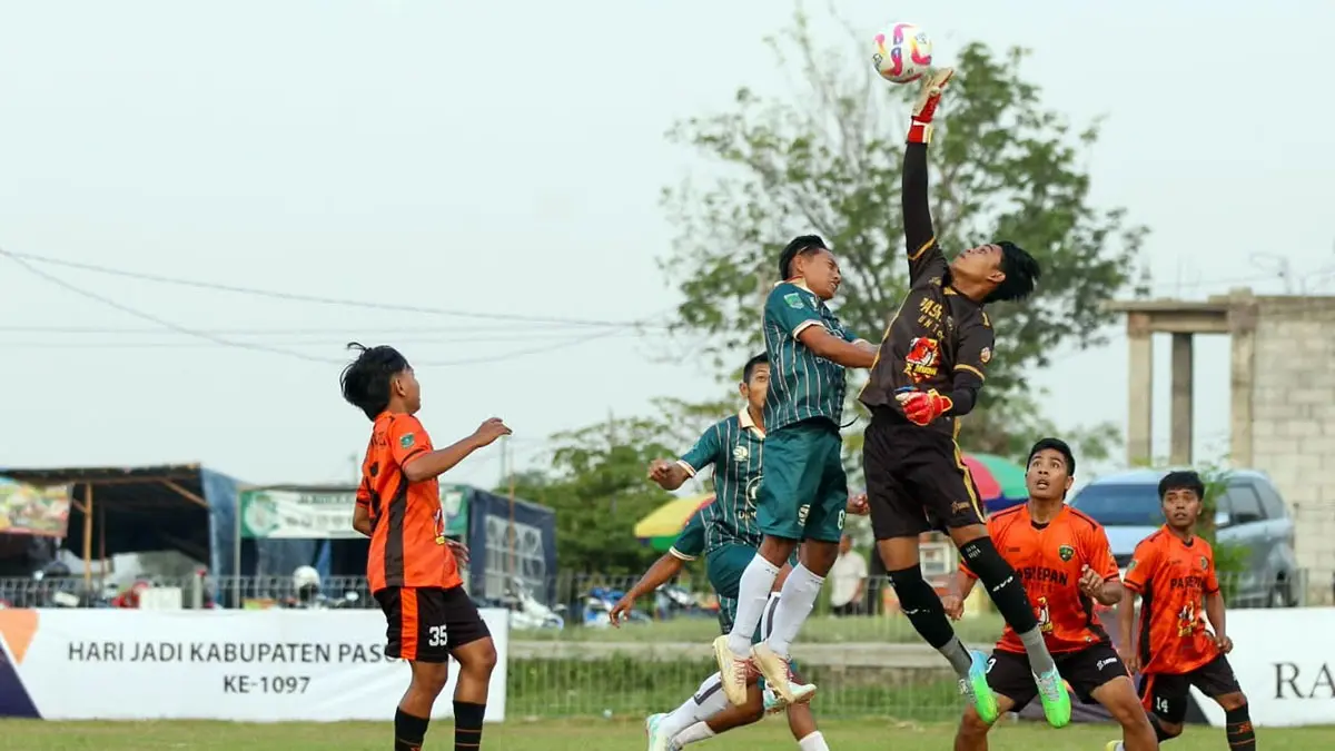 DUEL BOLA ATAS: Striker Sukorejo United berebut bola dengan penjaga gawang Pasrepan United. Dalam laga itu, Sukorejo United unggul 3-0. (Mokhamad Zubaidillah/ Radar Bromo)