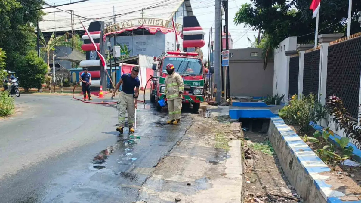 SEMPROT: Tim Damkar Satpol PP Kota Probolinggo membersihkan ceceran solar di Jalan Ki Hajar Dewantara, Kelurahan/Kecamatan Kademangan, Senin (31/8). (DAMKAR SATPOL PP KOTA PROBOLINGGO FOR&nbsp;JAWA POS RADAR BROMO)