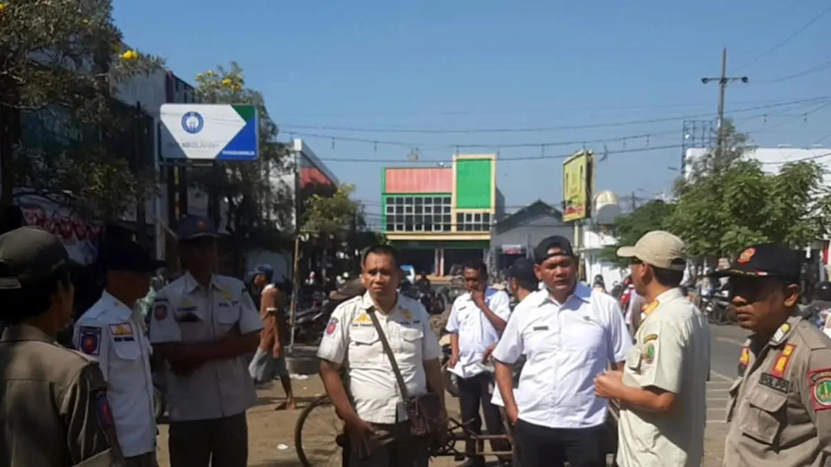 Petugas Satpol PP Kota Pasuruan saat melakukan operasi pada pedagang yang jualan di luar pasar Besar. 
