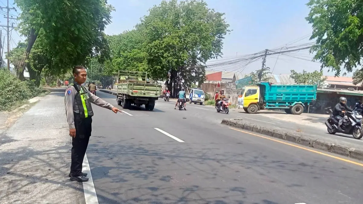 TUNJUKKAN: Petugas kepolisian menunjukkan lokasi kecelakaan yang menewaskan satpam pabrik. (Unit Lantas Polsek Gempol for Radar Bromo)