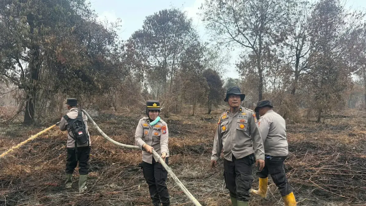 Personel Polda Riau melakukan pemadaman di kawasan karhutla. (Istimewa)

