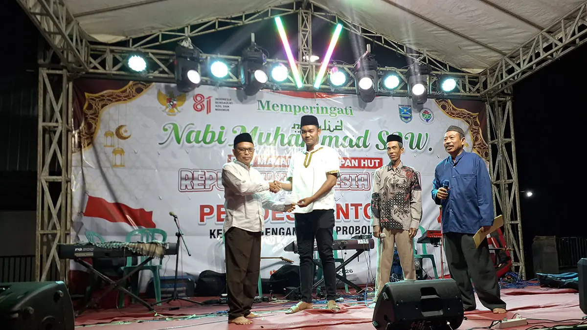 APRESIASI: Pj Kepala Desa Sentong Komaruddin menyerahkan uang pembinaan kepada salah satu juara lomba domino. (ISTIMEWA)