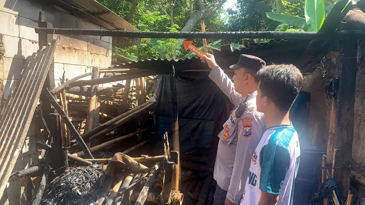 LUDES: Petugas kepolisian dari Polsek Lumbang saat memeriksa area dapur rumah milik Sakim, 53, pasca insiden kebakaran. (Polsek Lumbang for Radar Bromo)