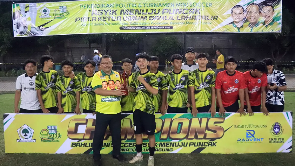 SEMRINGAH: Ketua DPD Partai Golkar Jawa Timur Ali Mufthi menyerahkan piala juara 1 Bahlil Mini Soccer Asyik Menuju Puncak Zona 3 Tulungagung pada tim SMAN 1 Kauman usai partai final yang menegangkan, Selasa malam (8/9). (Devrat Ramanda/Radar Tulungagung)