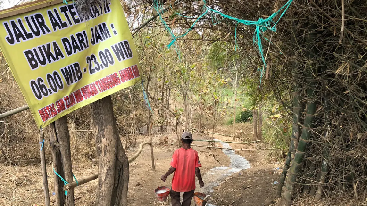 DIPERBAIKI: Seorang pekerja melapis pasangan batako dengan semen di jalur alternatif Jembatan Curahbubur, Kecamatan Tegalsiwalan, Kabupaten Probolinggo, Jumat (11/9). (Inneke Agustin/ Radar Bromo)