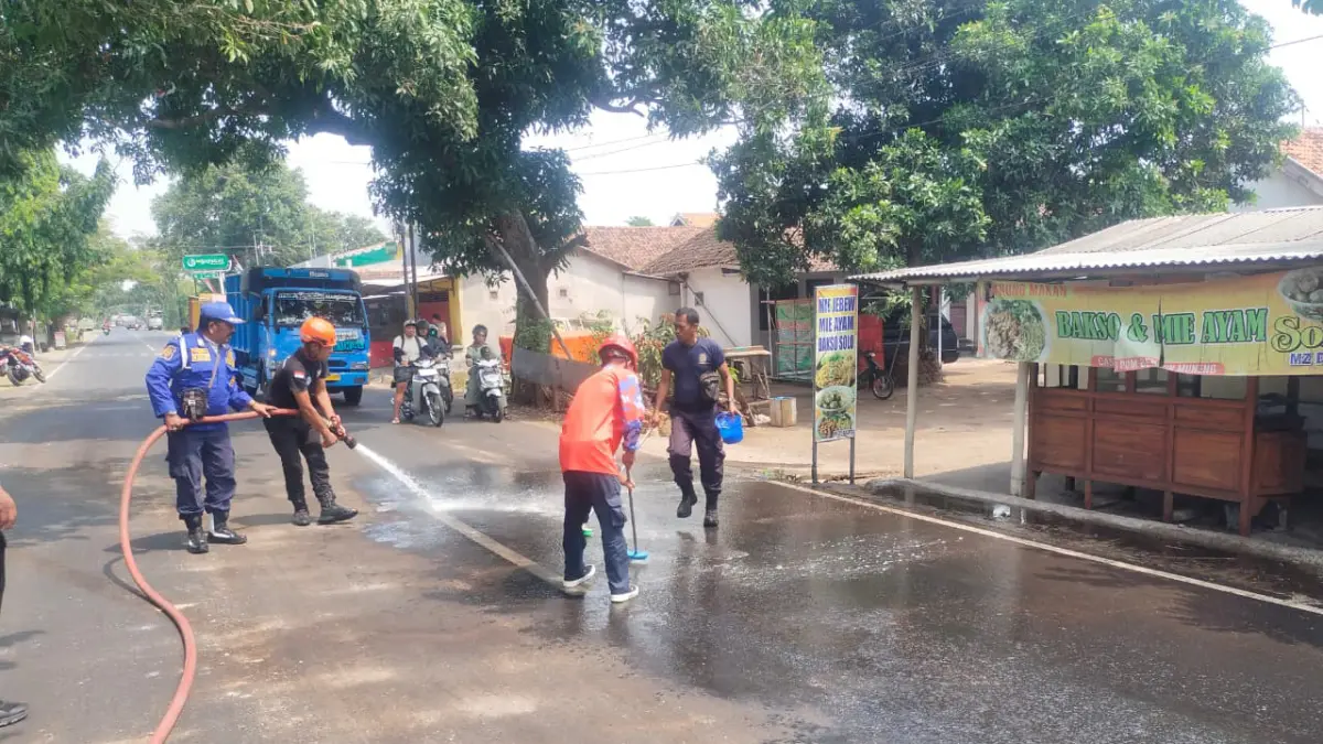 SIRAM: Tim Damkar membersihkan ceceran solar di Jalan Semeru, Kelurahan Triwung Kidul, Kecamatan Kademangan, Kamis (10/9) siang. (DAMKAR SATPOL PP KOTA PROBOLINGGO FOR&nbsp;JAWA POS RADAR BROMO)