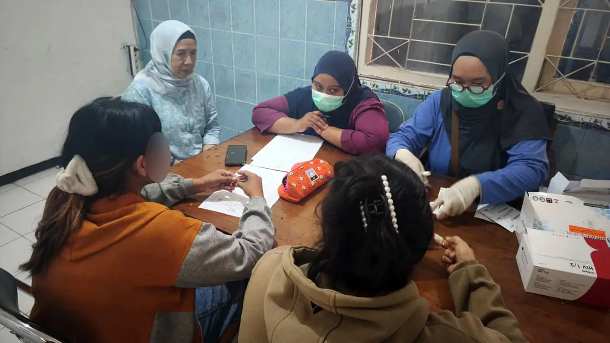 DIDATA: Petugas dari Dinkes saat melakukan tes kesehatan pada 2 perempuan PSK yang diamankan dari kawasan Embong Miring Tegalsiwalan, Probolinggo.