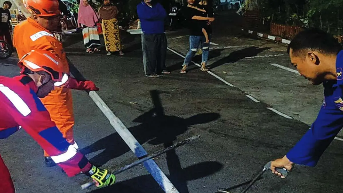 EVAKUASI: Tim Damkar Satpol PP Kota Probolinggo mengevakuasi ular kobra di dalam pipa besi, Sabtu (12/9) malam. (DAMKAR SATPOL PP KOTA PROBOLINGGO FOR JAWA POS RADAR BROMO)