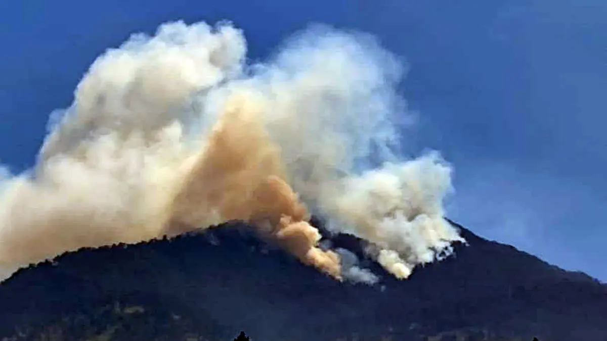 KEMBALI MEMBARA: Api kembali membakar Blok Lali Jiwo di lereng Gunung Arjuno. Kepulan asap terlihat di blok itu melalui Desa Dayurejo, Prigen, Kabupaten Pasuruan, Minggu (13/9). (Rizal Syatori/ Radar Bromo)