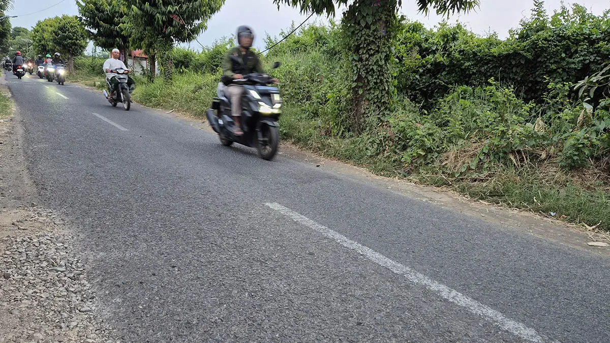 PERBAIKAN TERBATAS: Pengendara melintas di Jalan Kejobo, Blandongan, Kota Pasuruan. Jalan setempat hanya bisa ditambal sulam untuk titik yang mengalami kerusakan. (Fahrizal Firmani/Radar Bromo)