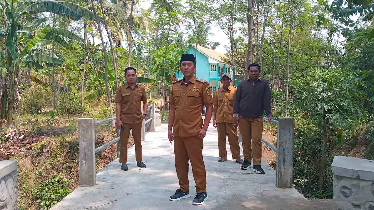 MAKIN KOKOH: Kepala Desa Bulujaran Kidul Poniman (depan) menunjukkan hasil pembangunan jembatan di Dusun Kosambi, RT 13/RW 2.