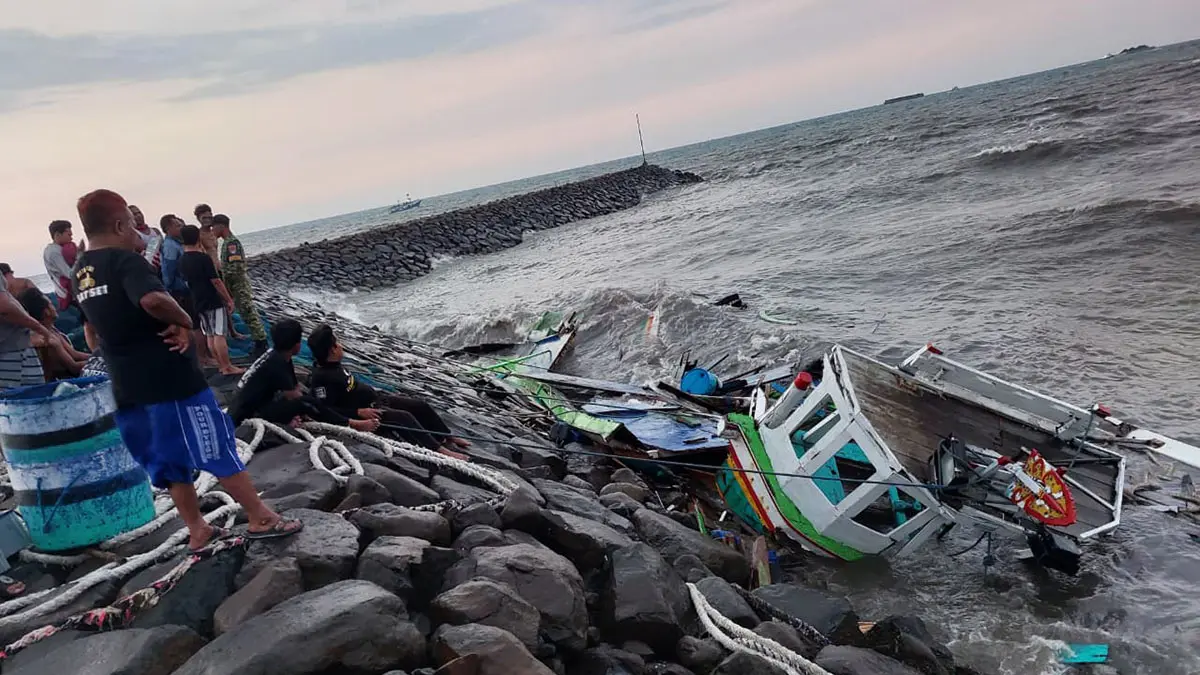 RUSAK: Sejumlah ABK KM Pantai Bali mengevakuasi bangkai kapal yang terhantam ombak di perairan Pelabuhan Perikanan Pantai (PPP) Paiton, Kabupaten Probolinggo, Senin (14/9) sore. (POSAL PAITON FOR JAWA POS RADAR BROMO)