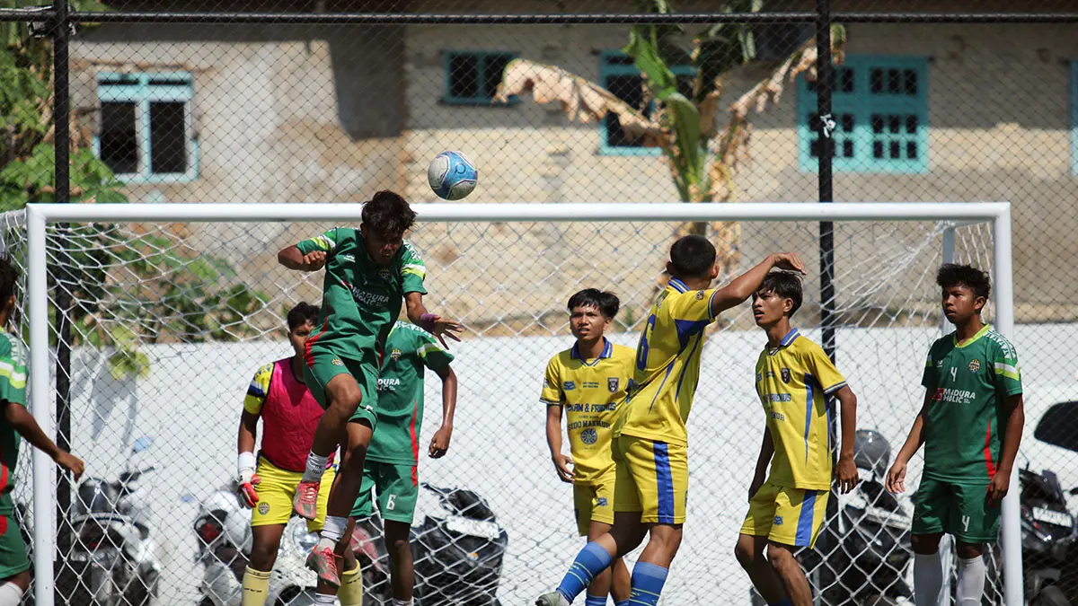 KETAT: Pemain MAN 2 Pamekasan (jersey hijau) menghalau bola atas saat mendapat serangan dari pemain-pemain SMAN 4 Pamekasan di Turnamen Bahlil Mini Soccer Asyik Menuju Puncak Zona 8 Madura di Puri Dewata Mini Soccer Pamekasan, (25/9). (Fahmi Jalil/ Radar Madura)