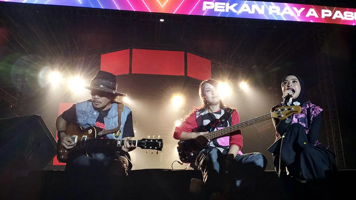 DEKAT: Tantri (vokal), Cella (gitar), dan Chua (bass) saat berusaha dekat dengan “Kerabat Kotak”. Mereka sukses menggebrak panggung Pekan Raya Pasuruan 2026, Kamis malam (24/9). (Rizal Syatori/Radar Bromo)