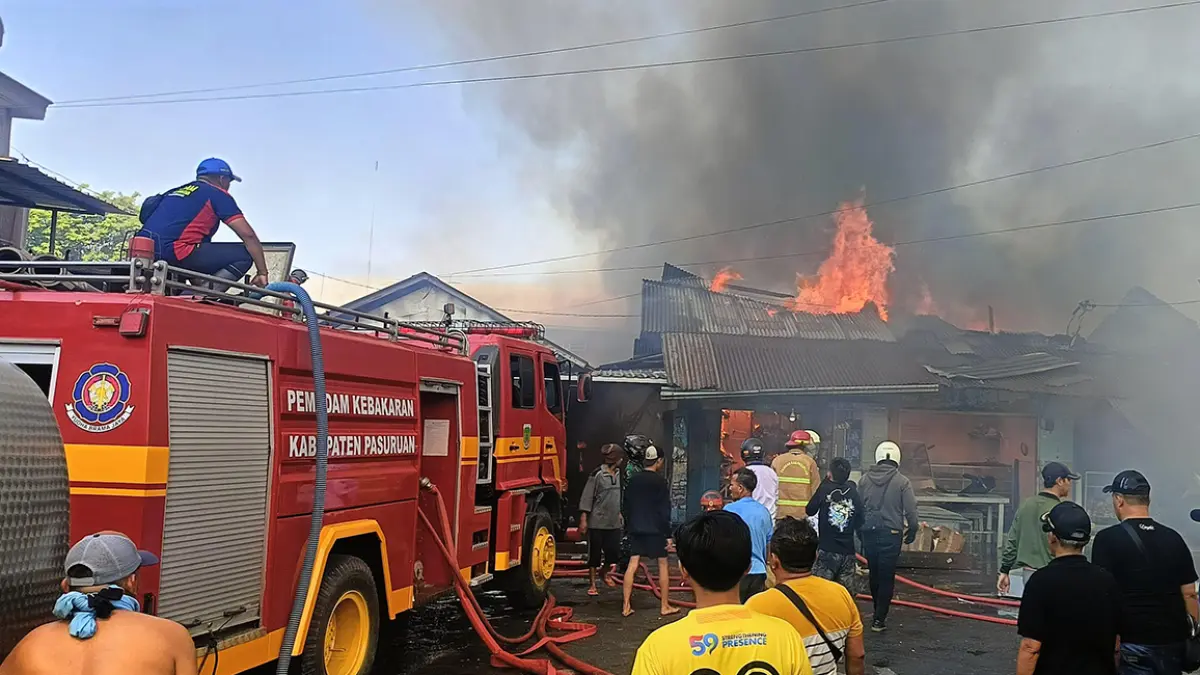 AMUK SI JAGO MERAH: Petugas saat berupaya memadamkan api yang menjilat kawasan pasar Kepulungan, Gempol, Sabtu (26/9).