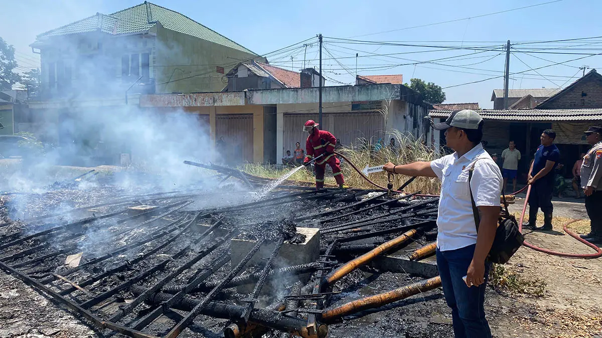LUDES: Petugas damkar Kabupaten Pasuruan saat melakukan pembasahan, untuk memastikan sisa-sisa api bisaa padam sepenuhnya. (Polsek Gempol for Radar Bromo)